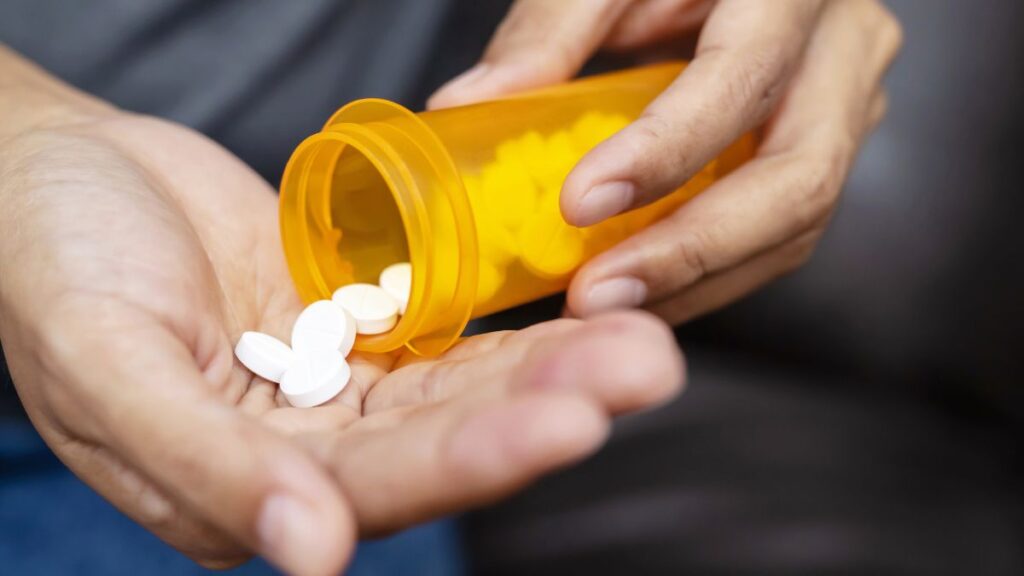 man holding a prescription bottle of pills going over medications for cocaine addiction