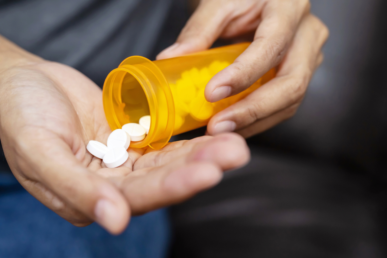 man addicted to muscle relaxers pouring a bottle of them in his hand