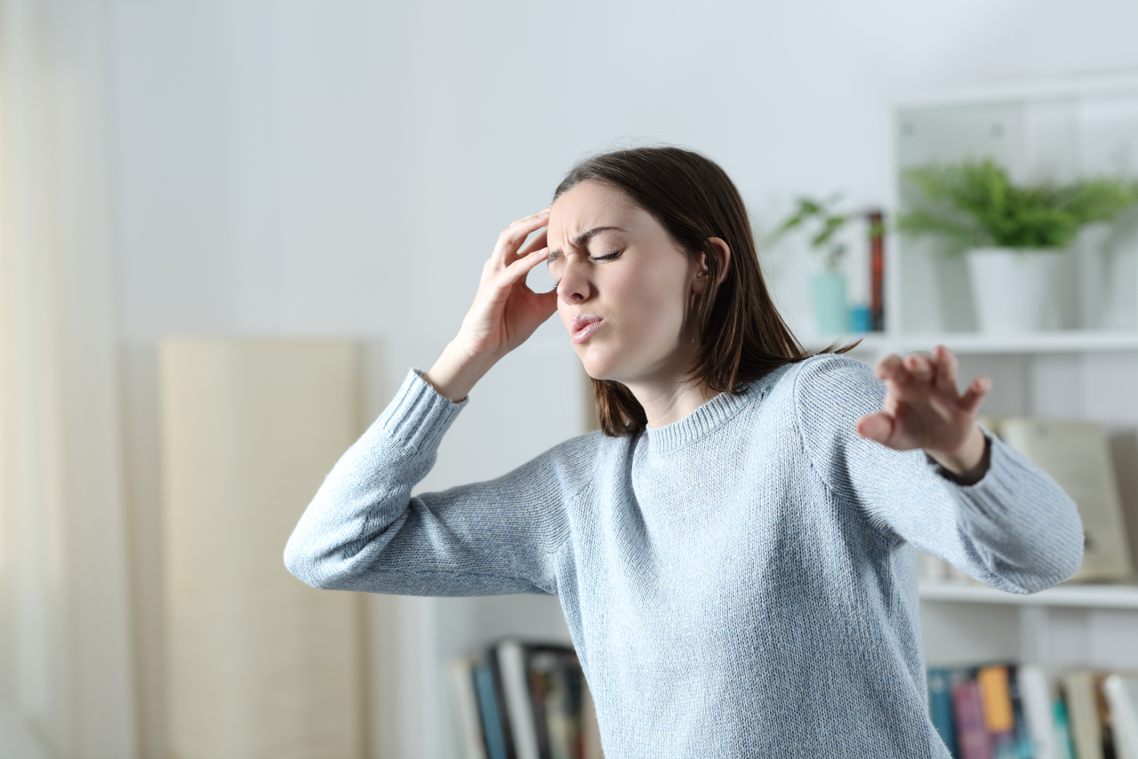 woman standing feeling dizzy wondering how long does dizziness from anxiety last?